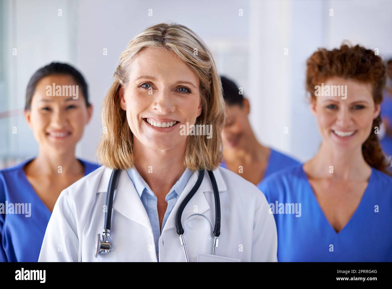 Vous pouvez leur faire confiance pour vos besoins en matière de soins de santé. Portrait d'une femme médecin mature avec un groupe d'infirmières debout derrière elle. Banque D'Images