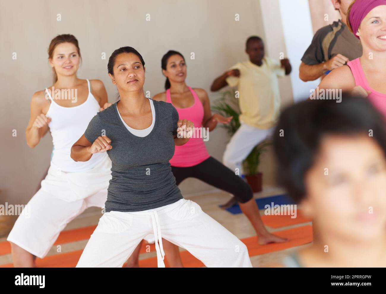 L'accent est essentiel dans le yoga. Un groupe d'élèves du yoga se concentrant sur leur forme pendant la classe. Banque D'Images