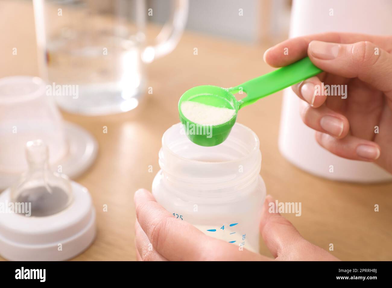 Femme préparant des préparations pour nourrissons à la table, en gros plan. Lait pour bébé Banque D'Images