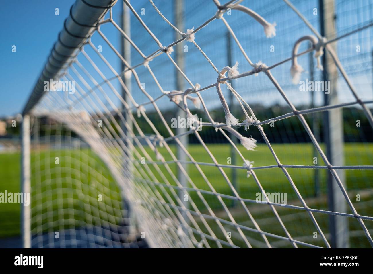 gros plan de la grille de football porte goalpost filet de corde blanc avec champ vert en arrière-plan Banque D'Images
