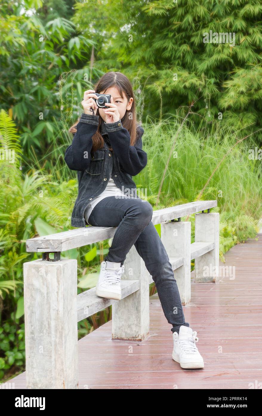 Jeune fille asiatique prenant des photos à l'extérieur Banque D'Images