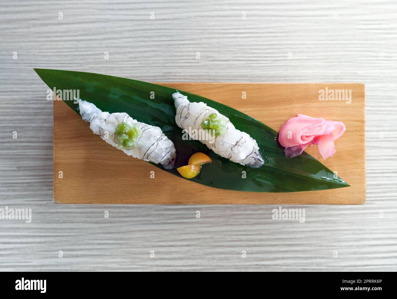 Shako Sushi servi sur une assiette en bois décorée de feuilles de bambou. Vue de dessus Banque D'Images