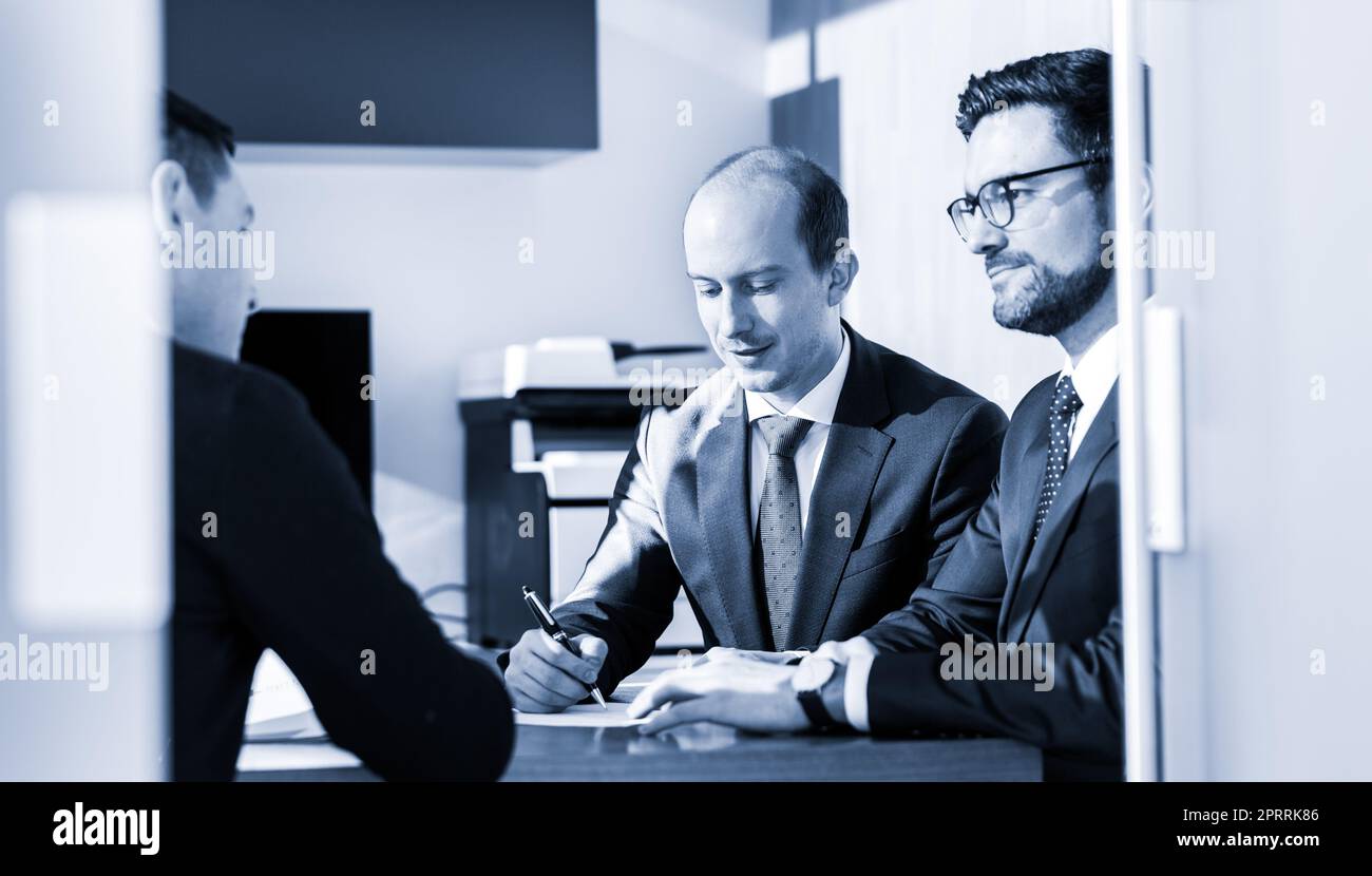 Groupe de confiance des gens d'affaires qui ont réussi l'examen et la signature d'un contrat à conclure l'affaire à la réunion d'affaires à l'entreprise moderne. Banque D'Images