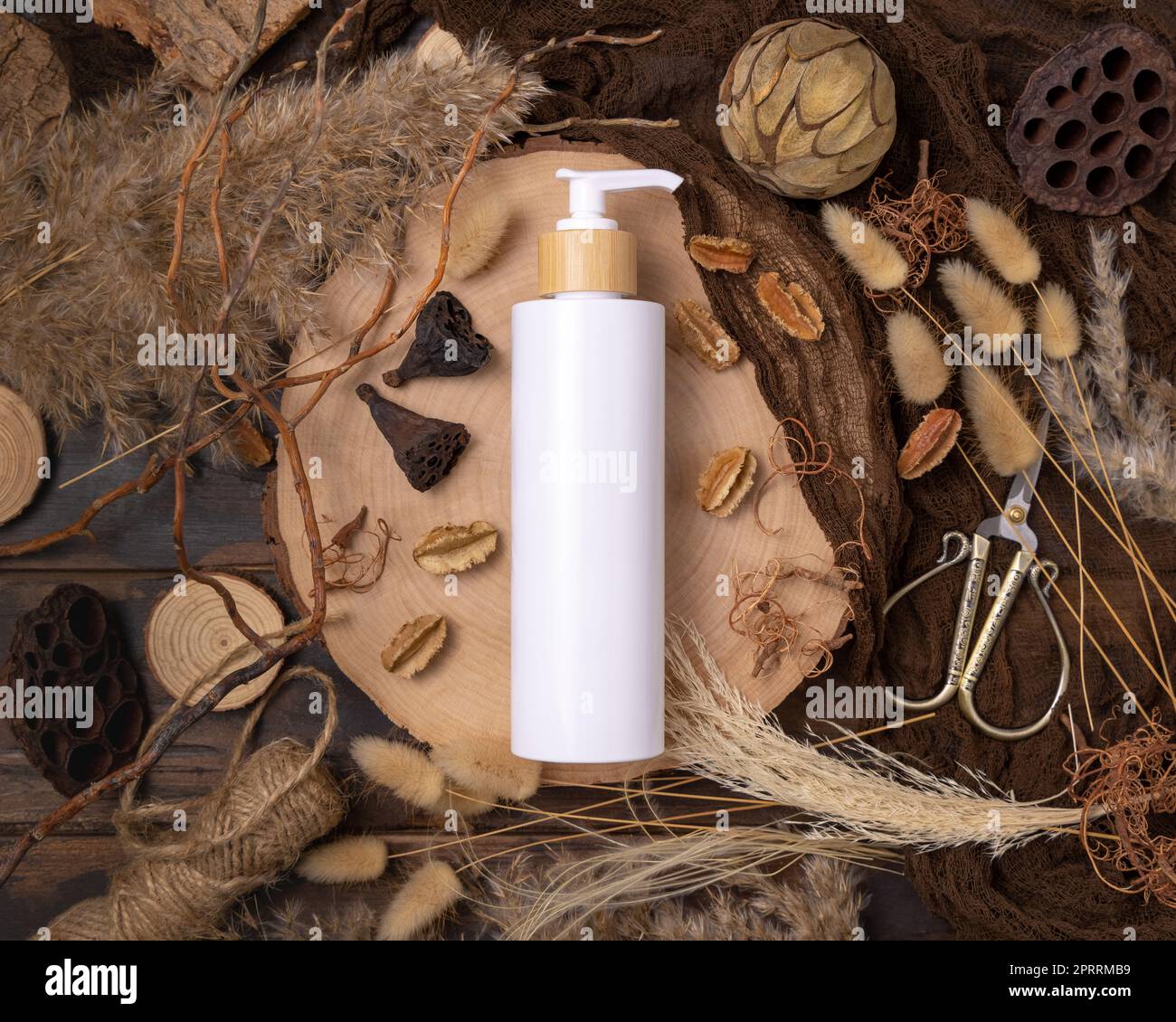 Cosmétique une bouteille de pompe sur bois près des décorations de boho naturel vue de dessus. Maquette d'étiquette Banque D'Images