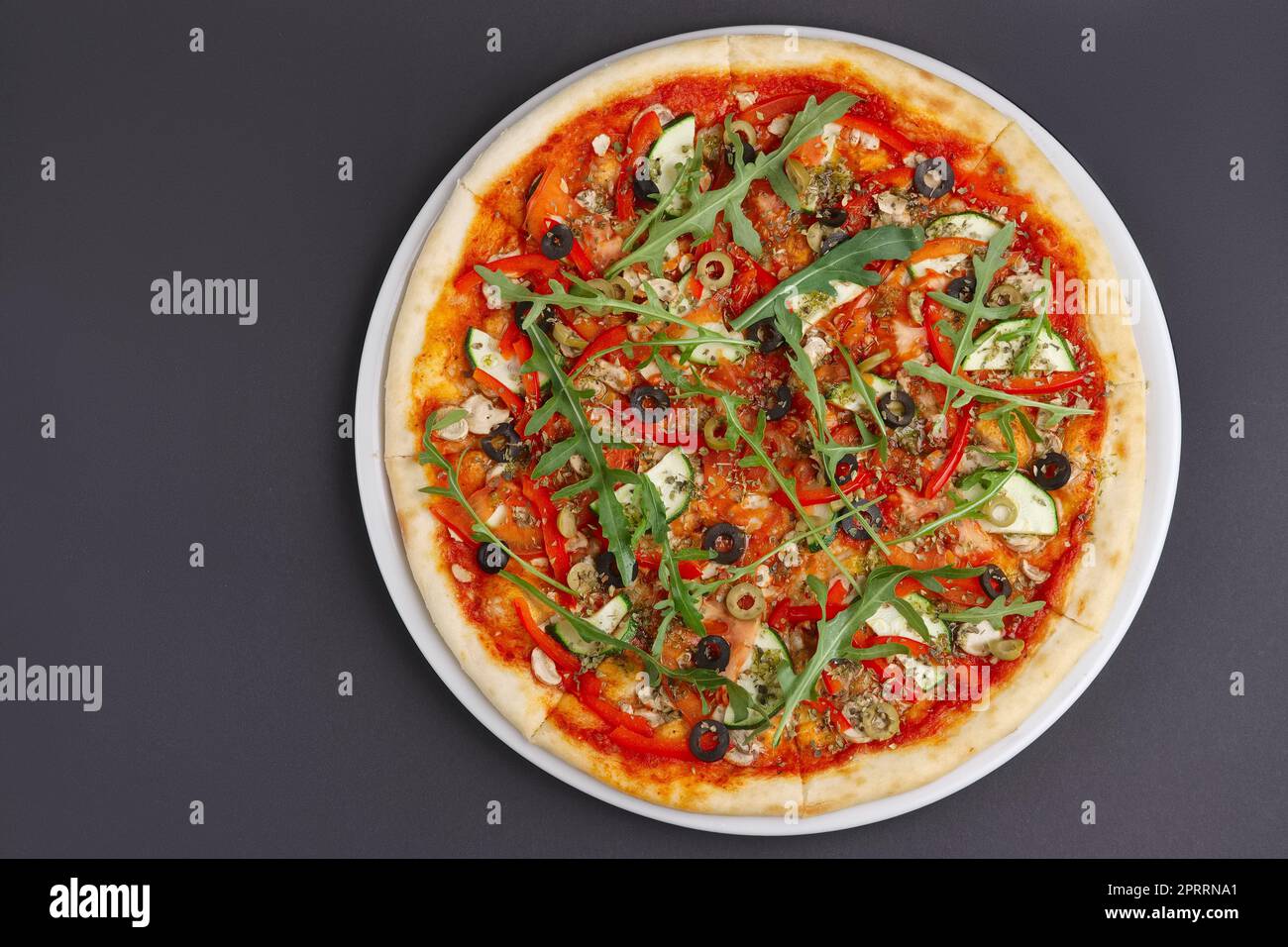 Pizza Margherita avec du fromage maigre, roquette, sauce tomate sur une plaque blanche. L'espace pour le texte. Banque D'Images