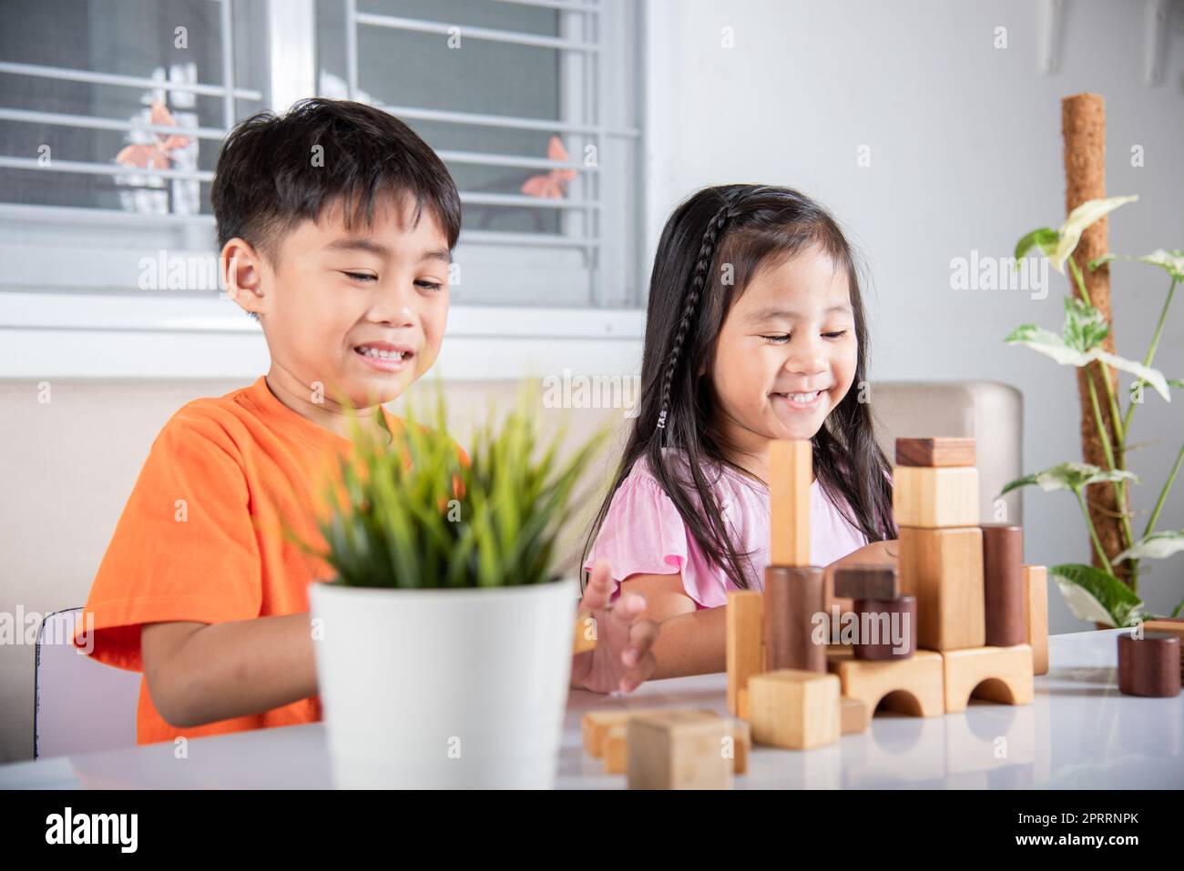 Enfants garçon et fille jouant avec constructeur en bois bloc bâtiment Banque D'Images