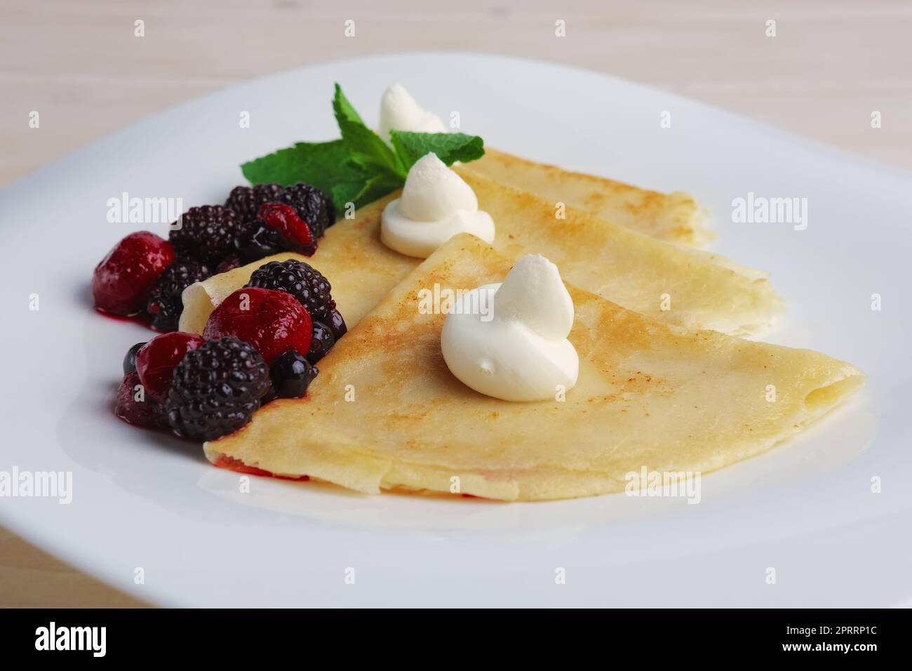Sur des crêpes fines avec du fromage à la crème et des baies. Banque D'Images