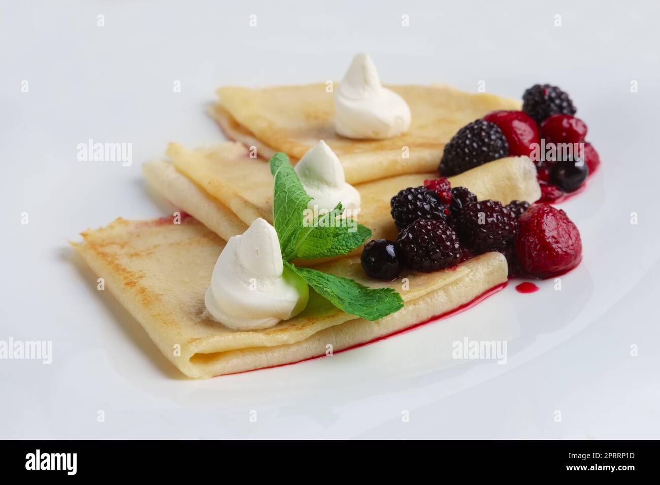 Sur des crêpes fines avec du fromage à la crème et des baies. Banque D'Images