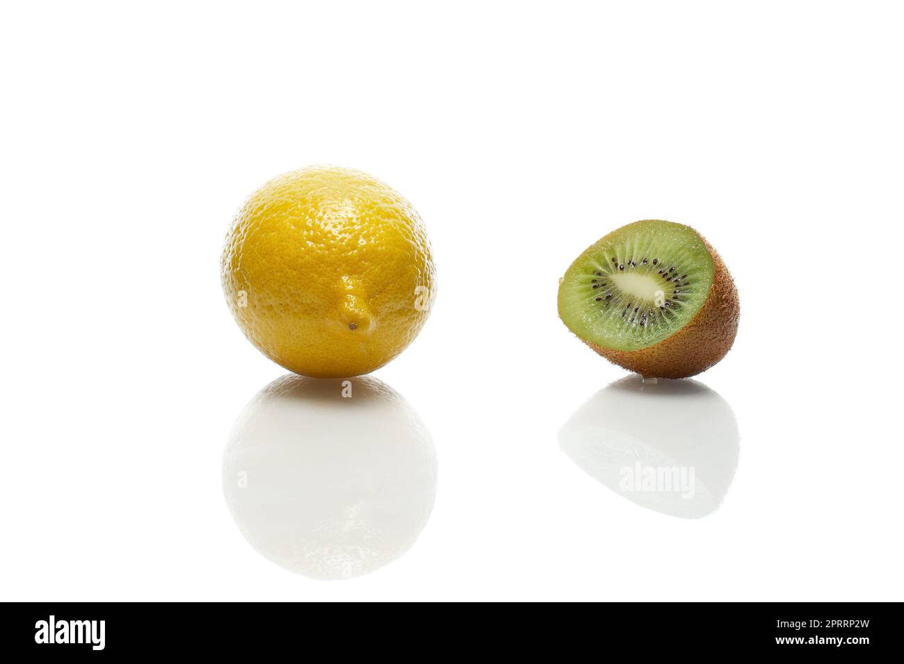 Citron et kiwi avec réflexion sur table en verre blanc Banque D'Images