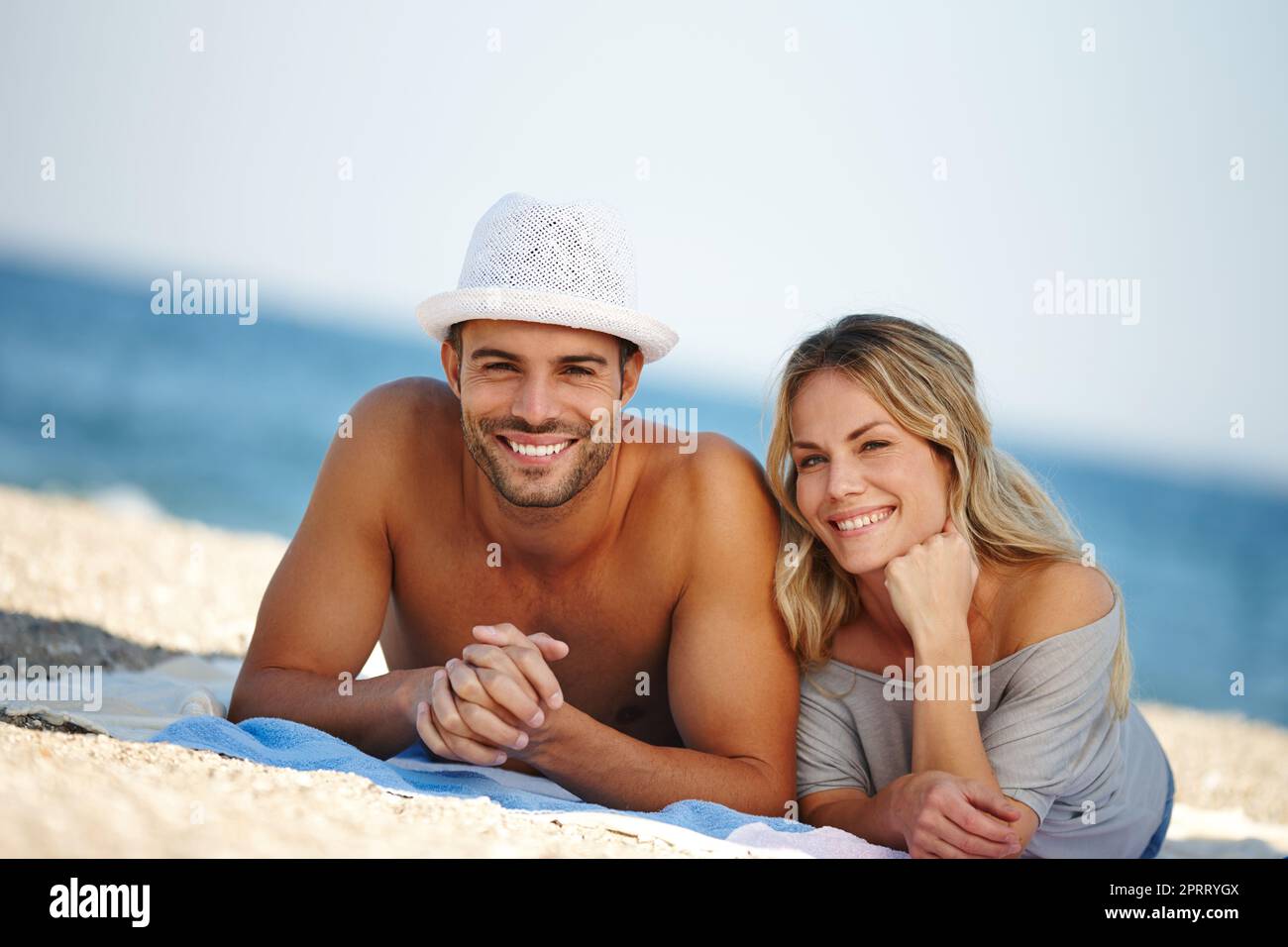 J'adore l'idyllique plage. Portrait d'un jeune couple heureux couché sur la plage Banque D'Images
