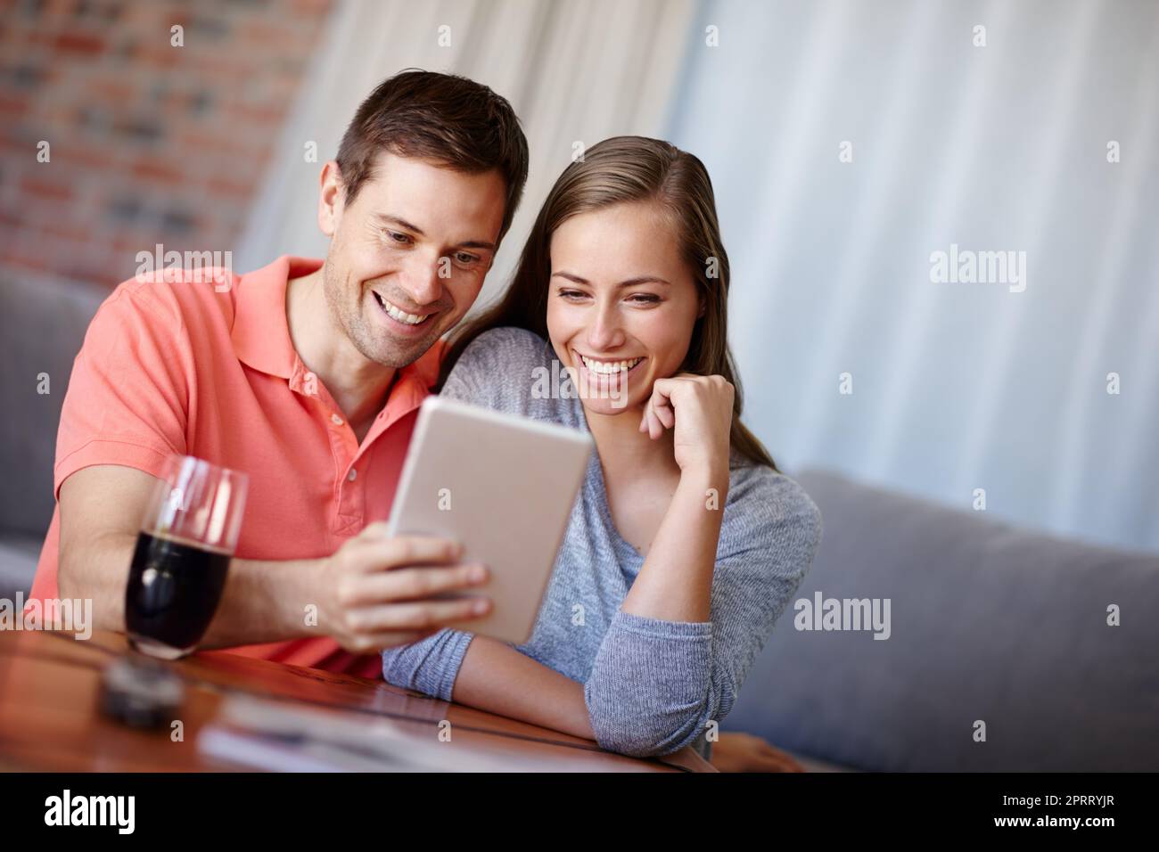 Prendre un trajet sur la voie de mémoire. Un jeune couple utilisant une tablette numérique à la maison Banque D'Images