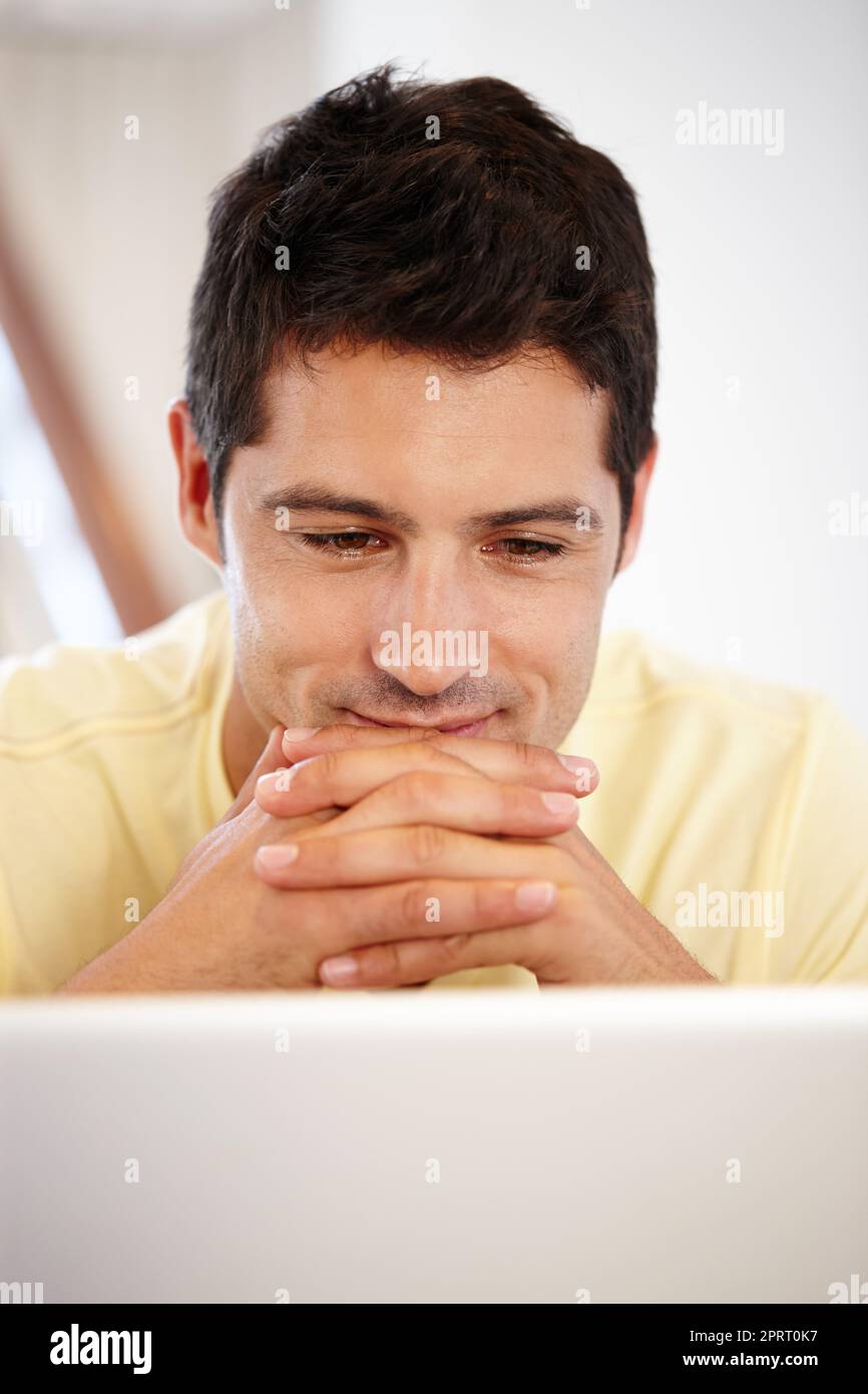 J'aurais voulu me rappeler tous mes mots de passe. Un jeune homme attrayant regardant son écran d'ordinateur Banque D'Images