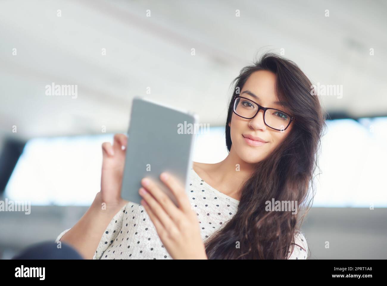 Votre présence en ligne est importante. Une jeune femme attrayante utilisant une tablette numérique Banque D'Images