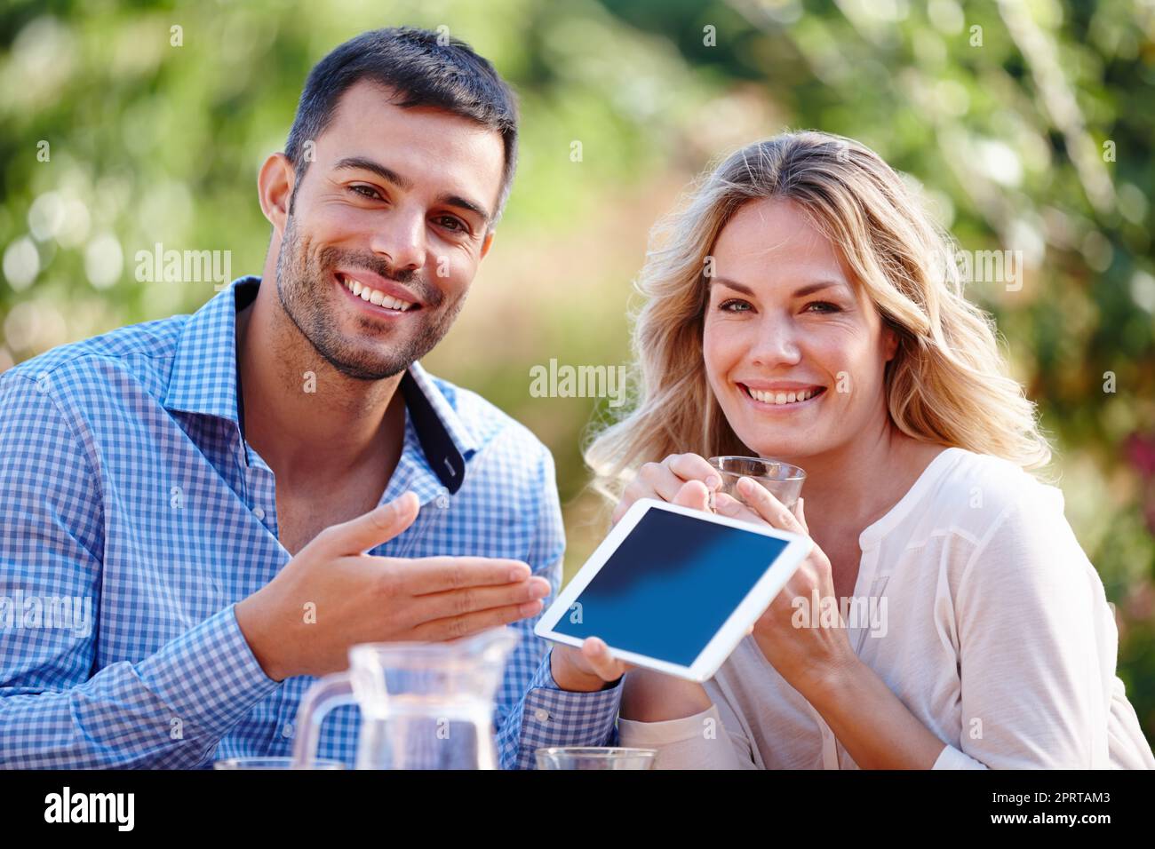 Le meilleur accessoire de voyage. Portrait d'un jeune couple utilisant une tablette numérique tout en prenant le petit déjeuner Banque D'Images