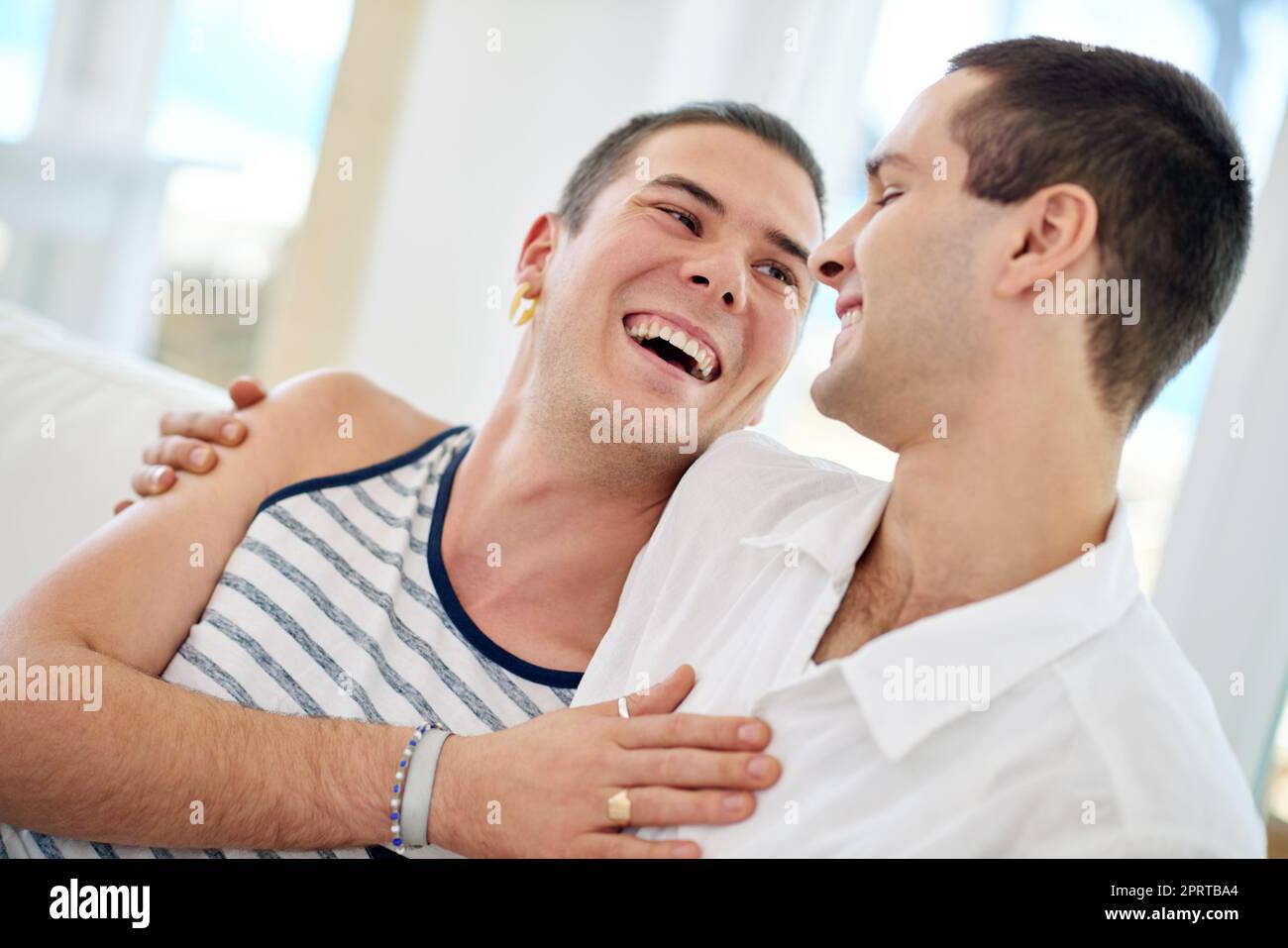 HES ma meilleure moitié. Un jeune couple gay se détendant sur un canapé à la maison. Banque D'Images