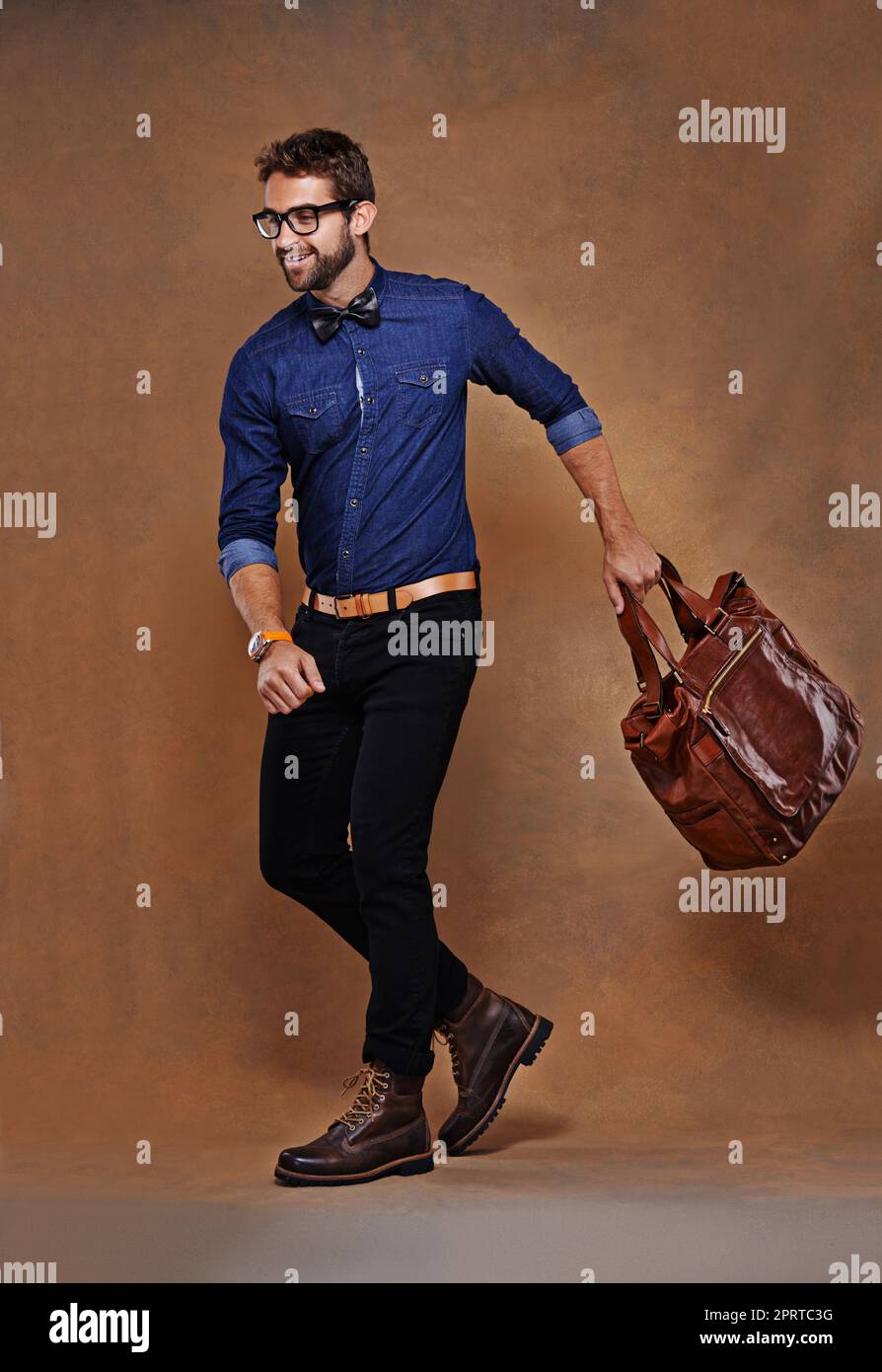 Il met rarement un pied mal à la mode. Un jeune homme habillé avec élégance  posant sur un fond marron Photo Stock - Alamy