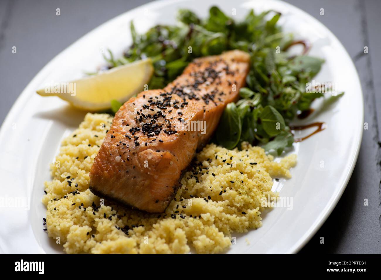 saumon cuit au four avec salade d'épinards et couscous Banque D'Images