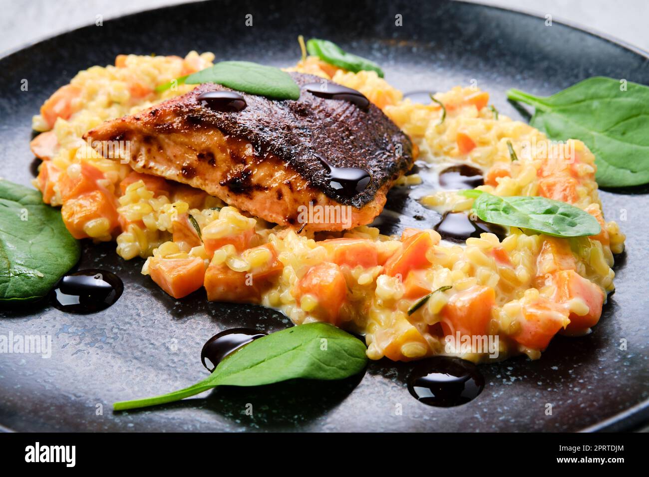 Vue rapprochée du steak de saumon frit servi avec bulgur et patate douce Banque D'Images