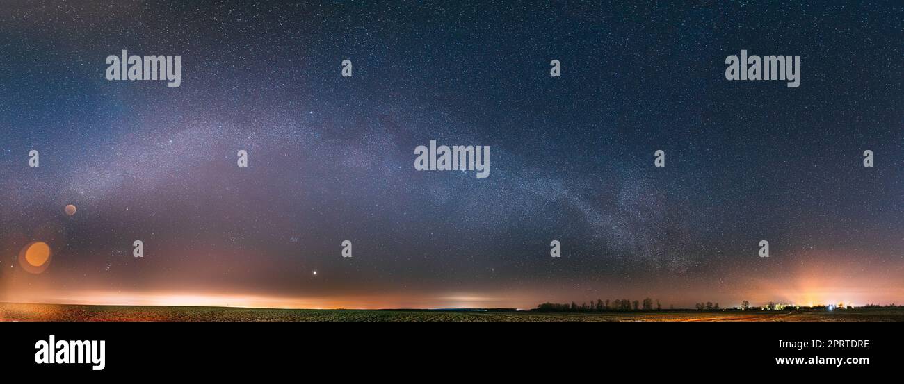 Ciel étoilé de nuit avec étoiles brillantes au-dessus du paysage de campagne. Milky Way Galaxy et Rural Field Meadow au début du printemps. Panorama, vue panoramique Banque D'Images