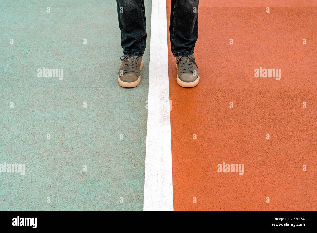 Homme debout sur le terrain de sport avec une ligne blanche entre ses jambes Banque D'Images