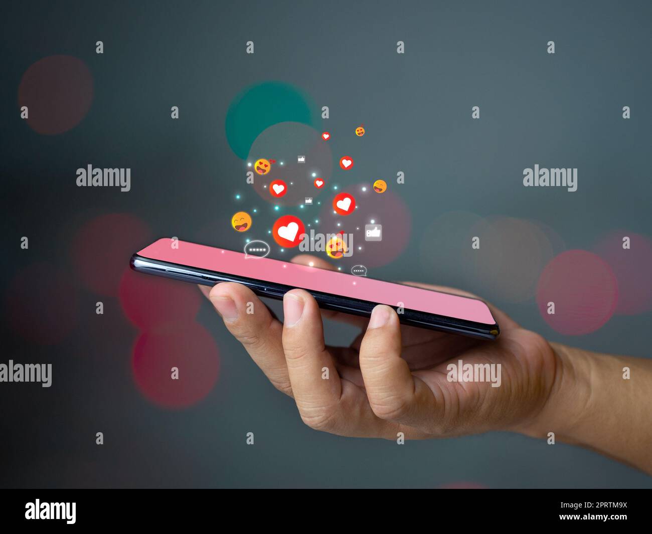 Médias sociaux et concepts de technologie, Une main d'homme tient un téléphone et il y a une icône de médias sociaux. Banque D'Images