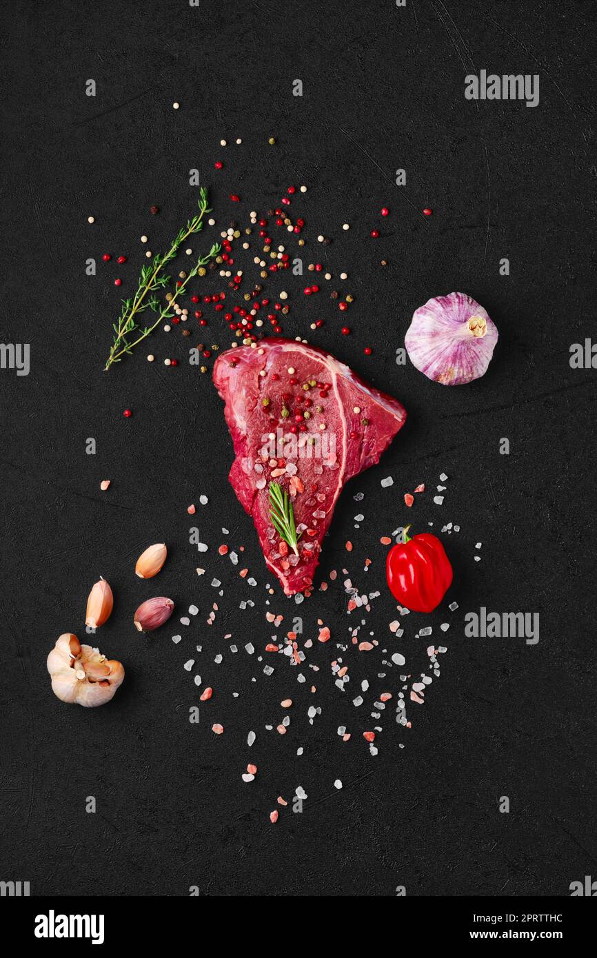 Vue de dessus du steak de l'œil de bœuf cru avec ingrédients pour la cuisson Banque D'Images