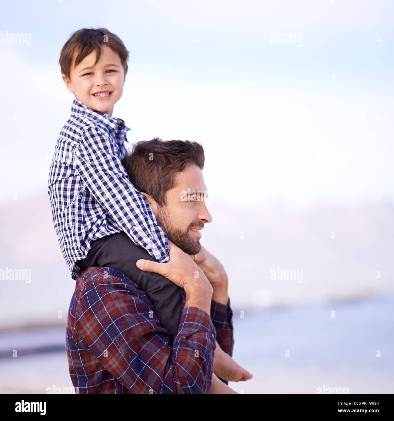 Plus tard, on allait obtenir de la crème glacée. Un père portant son jeune fils sur ses épaules avec un sourire Banque D'Images