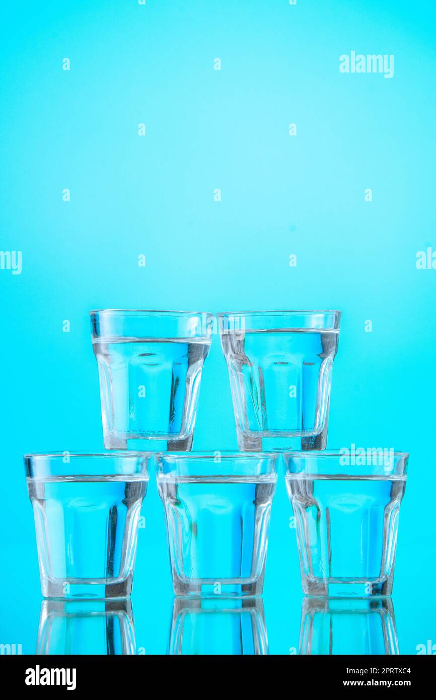 vue de face des verres à eau empilés les uns sur les autres sur fond bleu  clair Photo Stock - Alamy