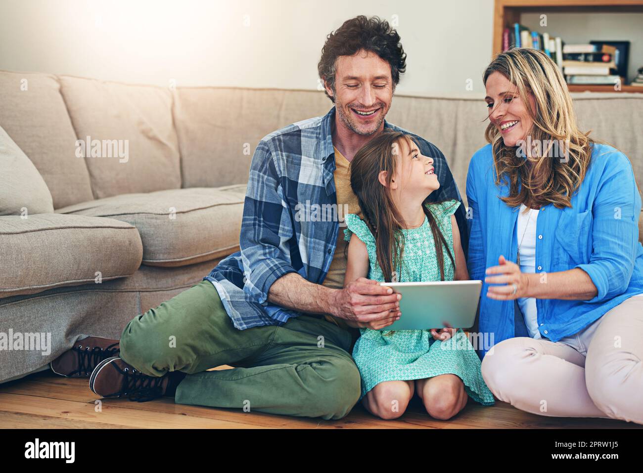 À votre tour de jouer maintenant, maman. une famille heureuse utilisant une tablette numérique à la maison Banque D'Images