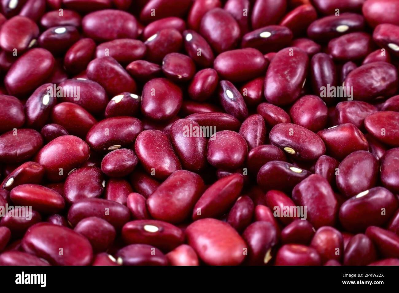 Gros plan sur la texture rouge vif des haricots rouges. Banque D'Images