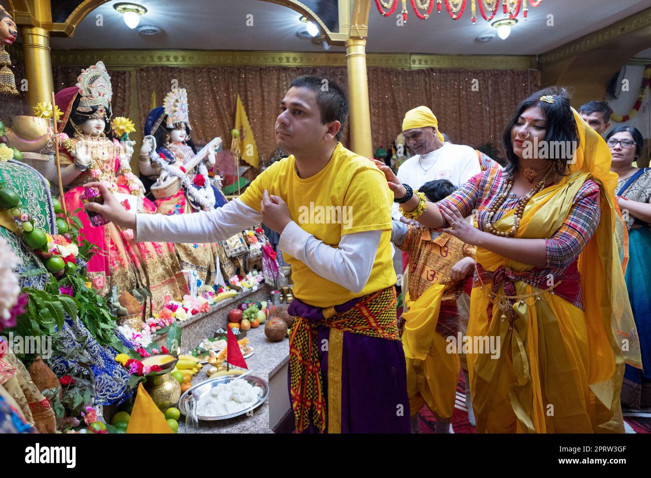 Un couple hindou se culpe dans un temple de Queens, New York. On croit que toucher augmente la puissance de la prière et la force des bénédictions. Banque D'Images