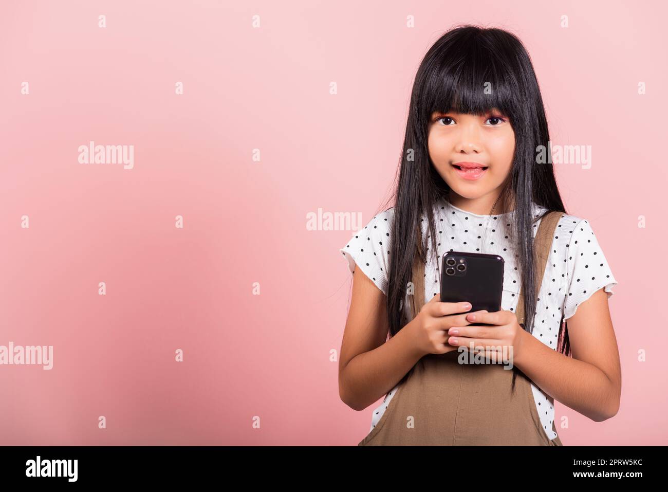 Enfant asiatique 10 ans en train d'utiliser un téléphone mobile pour les réseaux sociaux Banque D'Images