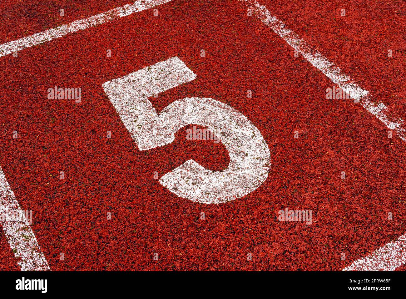 Le numéro 5 au point de départ de la piste de course ou de la piste d'athlète dans le stade Banque D'Images