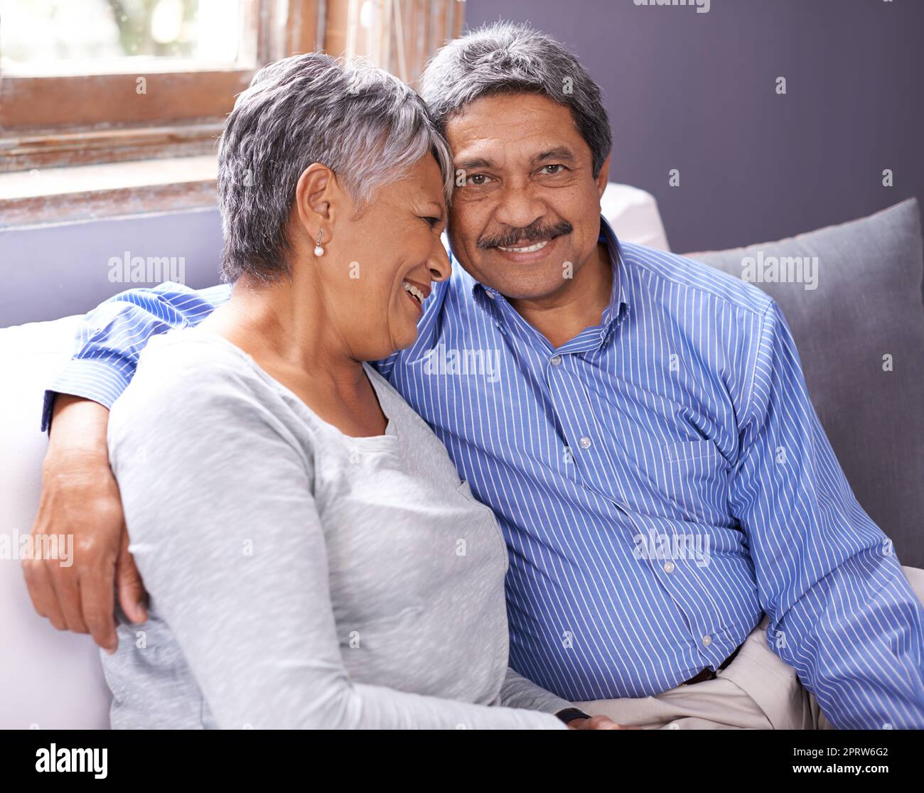 Un couple affectueux et mûr assis sur son canapé. Banque D'Images