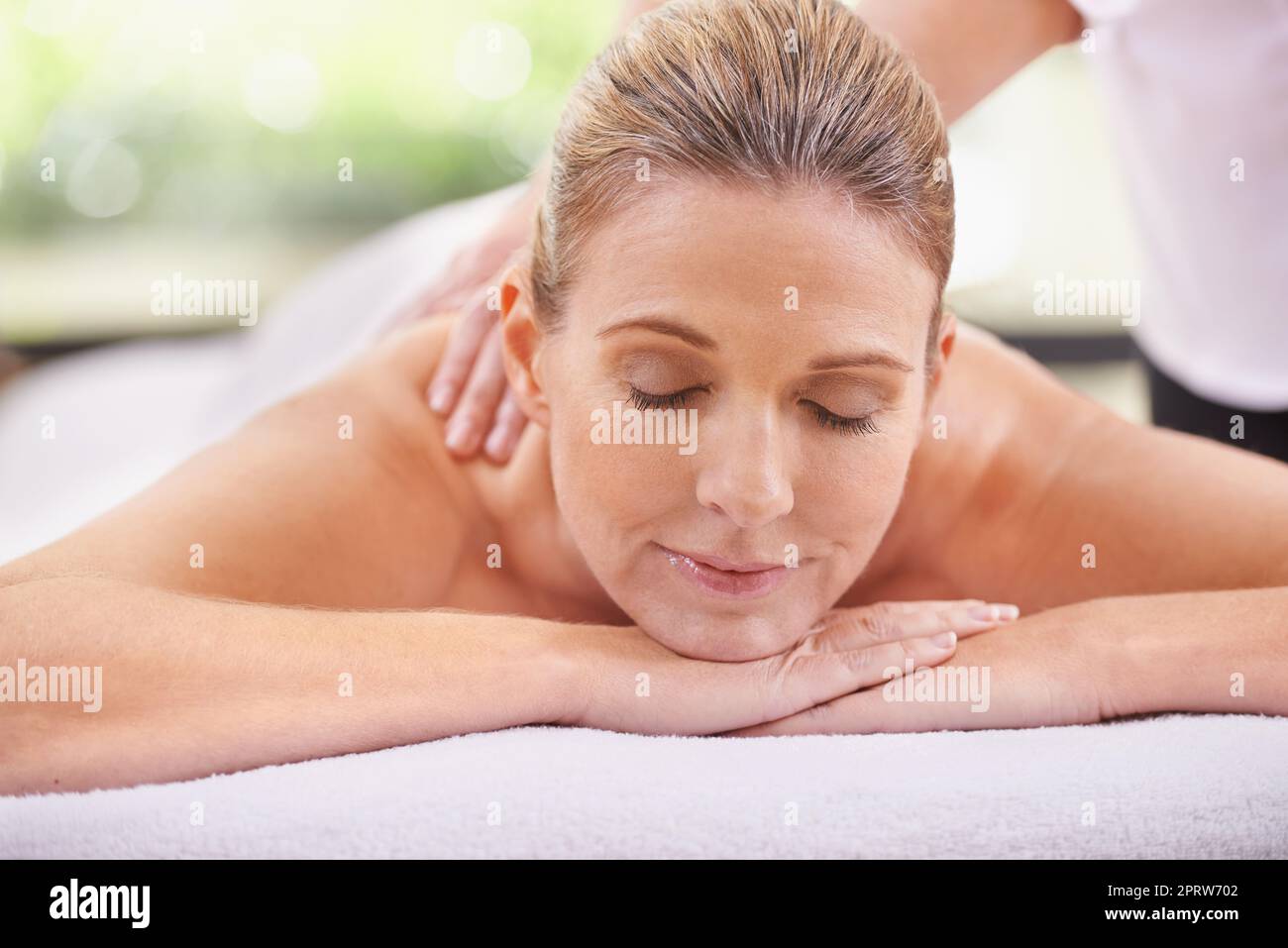 Un professionnel se fait dorloter. Une femme dans un spa de jour se détend sur une table de massage Banque D'Images