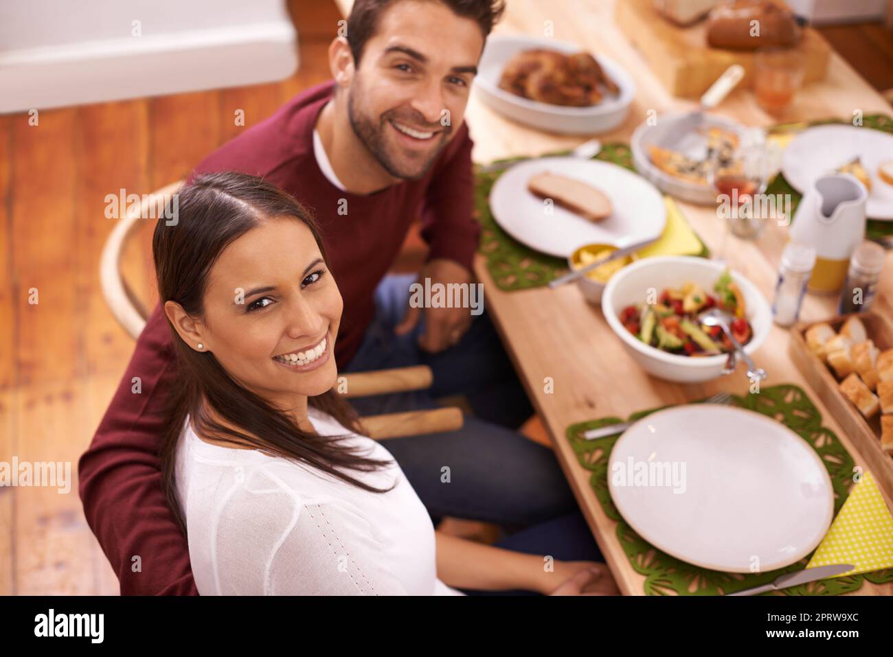 Le rire est plus brillant là où la nourriture est meilleure. Un couple heureux appréciant un repas de famille autour de la table Banque D'Images