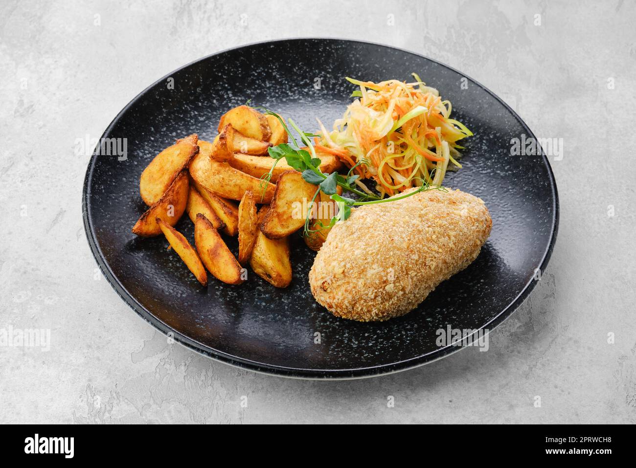 Côtelette farcie de fromage servie avec des quartiers de pommes de terre et de la choucroute Banque D'Images