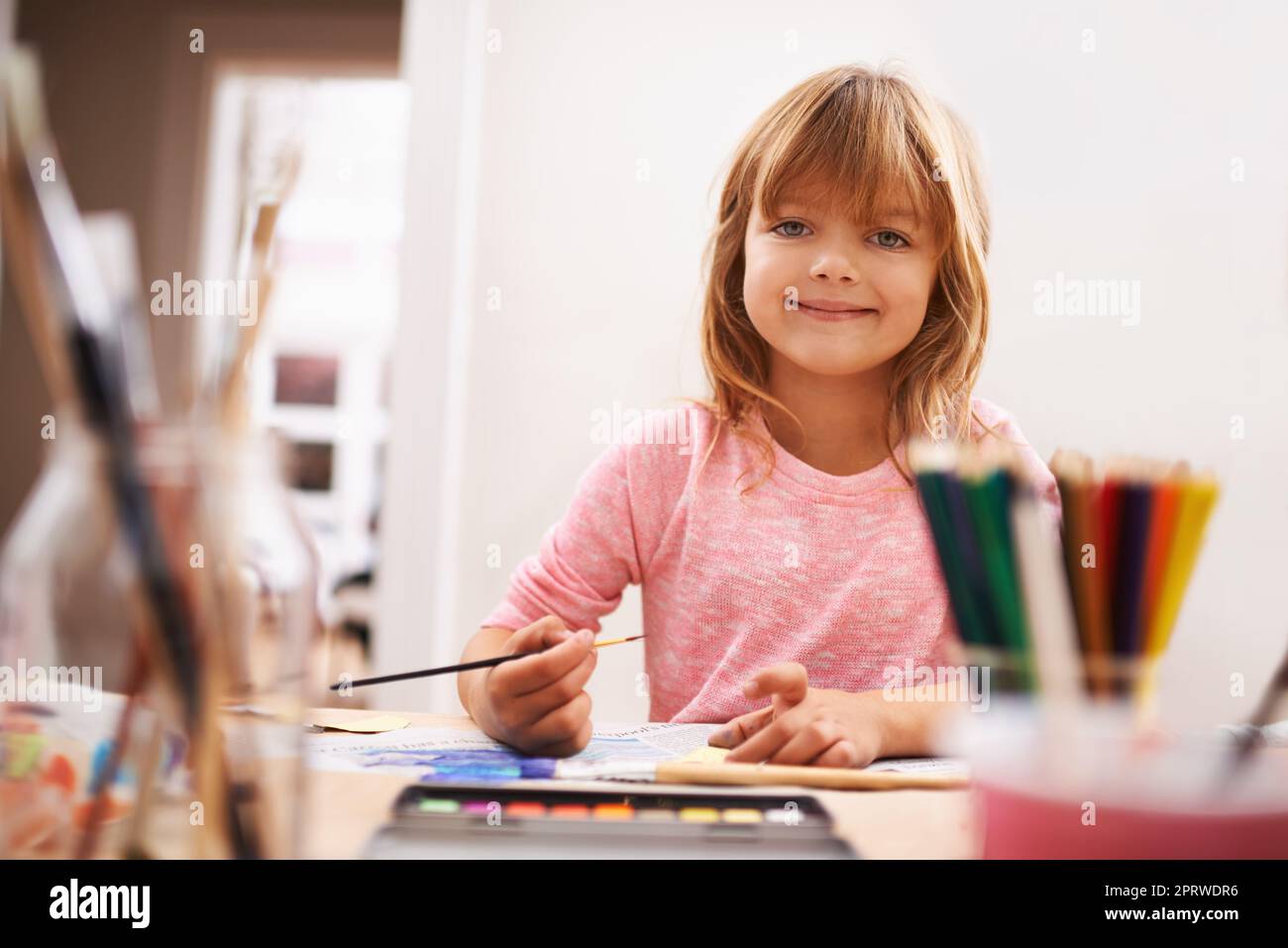 Shes si créatif. Portrait d'une petite fille qui peint à l'école Banque D'Images