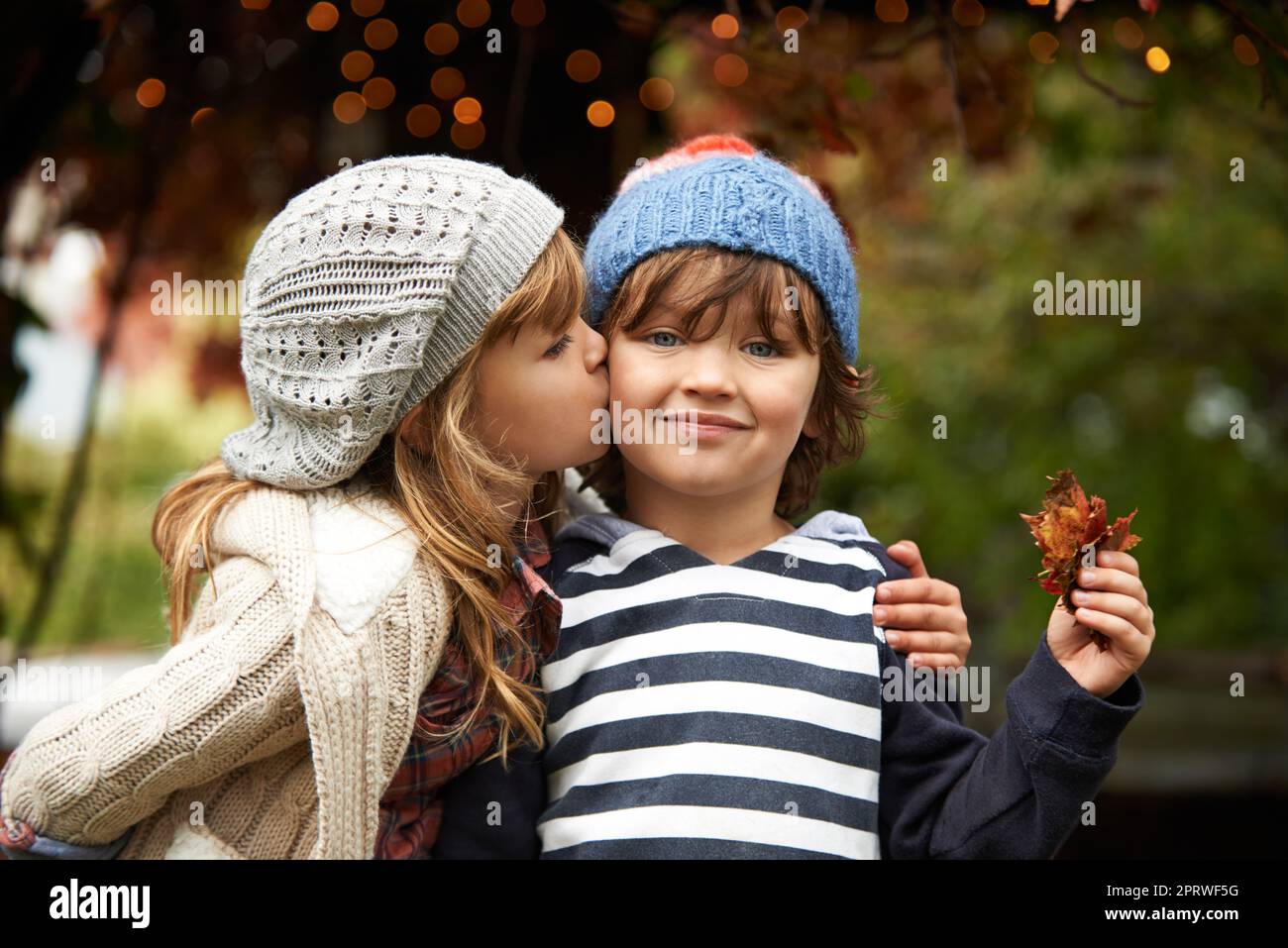 Pas de rivalité entre frères et sœurs ici. Une petite fille mignonne donnant à son frère un baiser sur la joue. Banque D'Images
