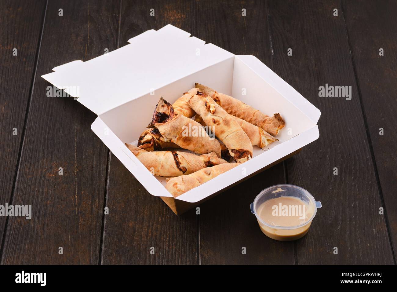 Tranches de poire roulé dans la pâte avec sauce caramel dans le paquet à emporter Banque D'Images