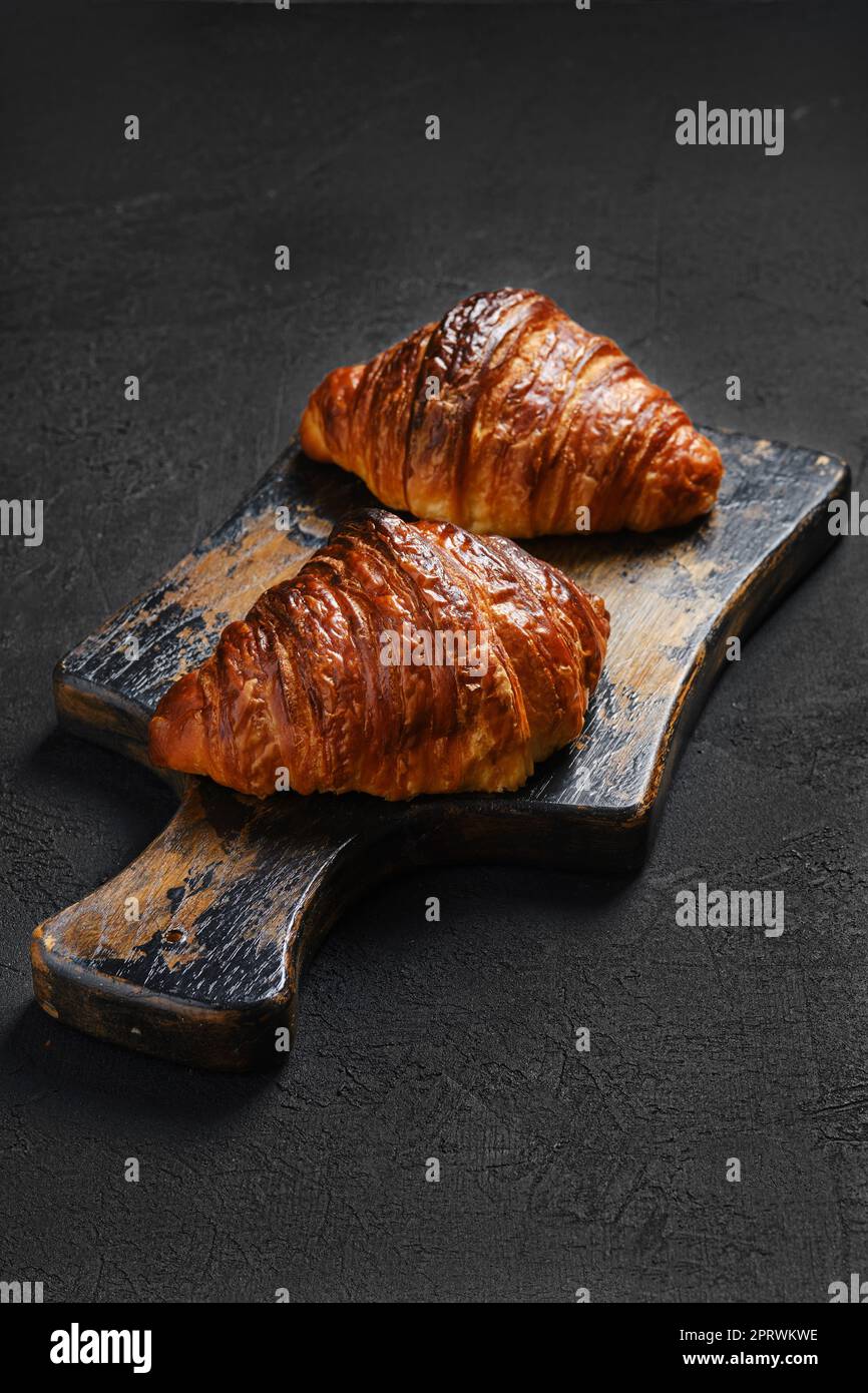 Croissant croustillant sur une planche de service à base de sorbde Banque D'Images Croissant croustillant sur une planche de service à base de sorbde Banque D'Images