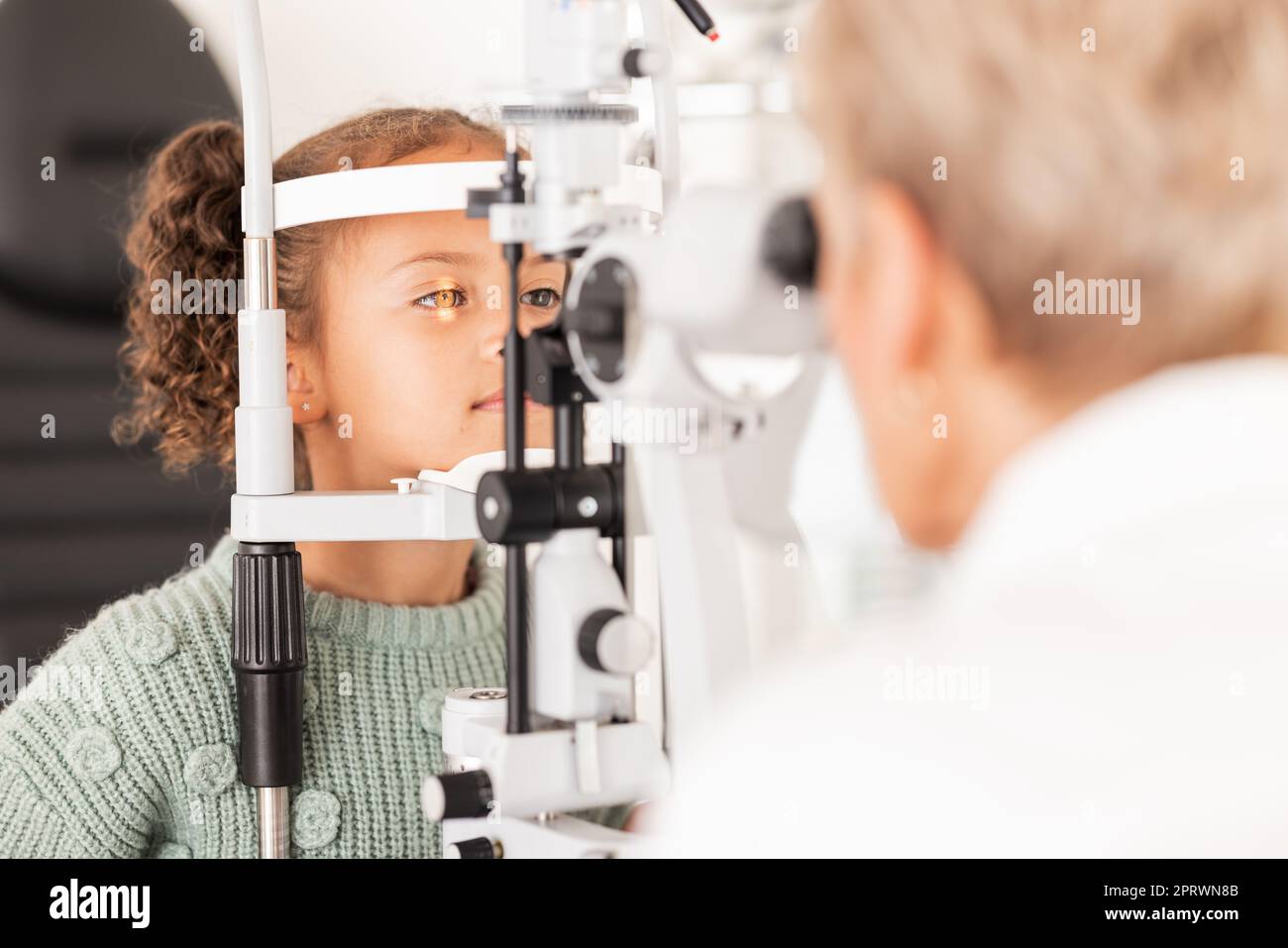 Enfant, enfant ou fille en optométrie examen oculaire avec optométriste, ophtalmologiste ou professionnel de la santé de consultation et lampe de fente de clinique. Test oculaire, enfants e Banque D'Images