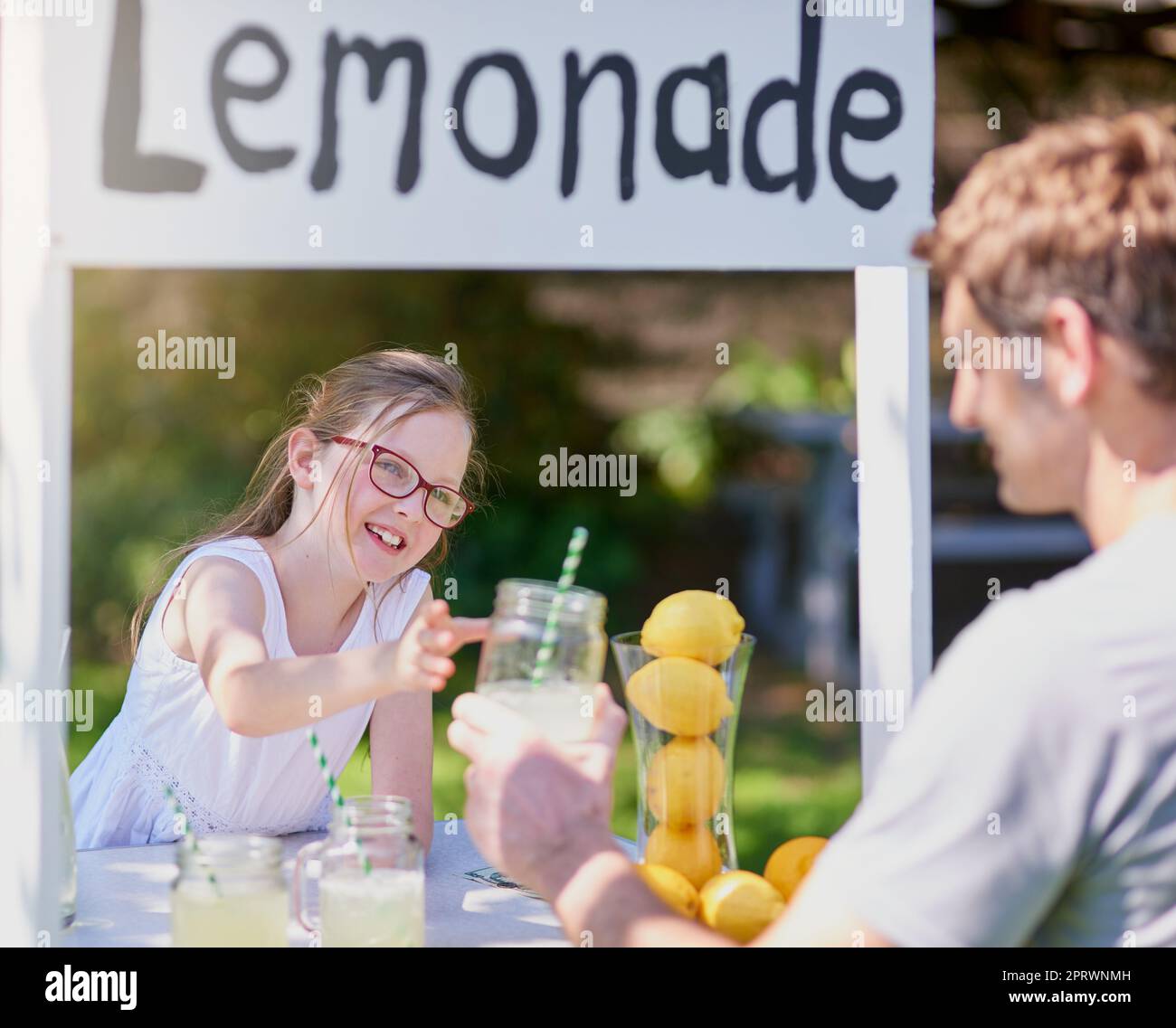 C'est un moyen amusant pour les enfants d'apprendre sur l'esprit d'entreprise. une petite fille qui vend de la limonade depuis son stand à l'extérieur Banque D'Images