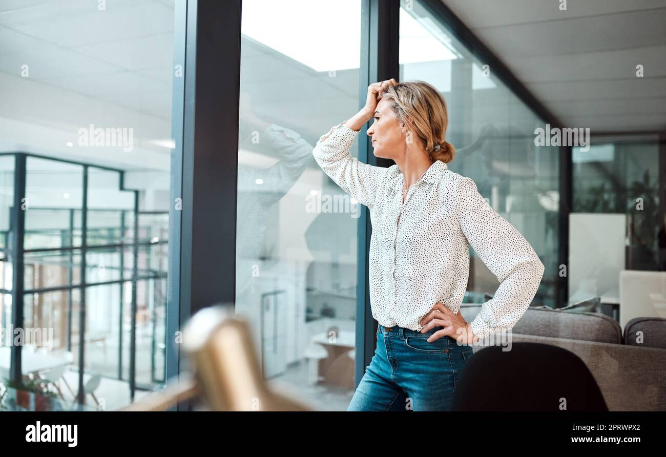 J'étais si motivée dans ma carrière. Une femme d'affaires mûre regardant stressée dans un bureau. Banque D'Images