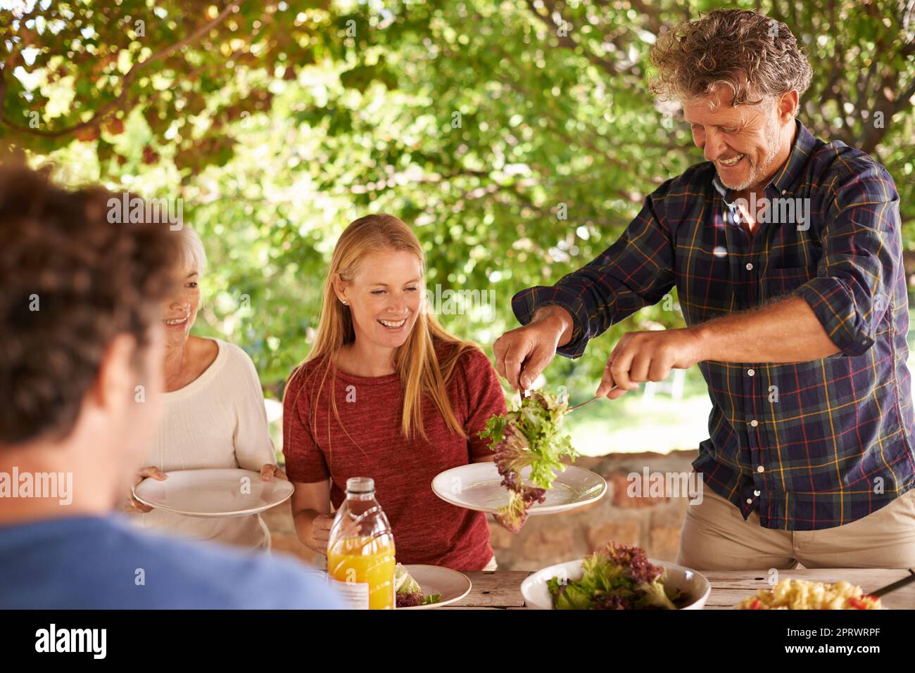 Cette salade toutes les laitues. Une vue d'une famille se préparant à manger le déjeuner ensemble à l'extérieur Banque D'Images