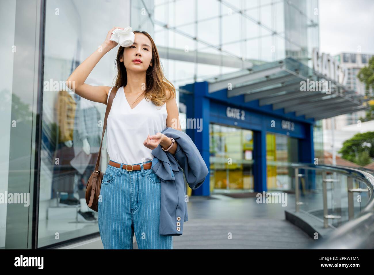 Asiatique belle femme d'affaires séchage de la sueur son visage avec un tissu dans chaud jour d'été chaud temps Banque D'Images