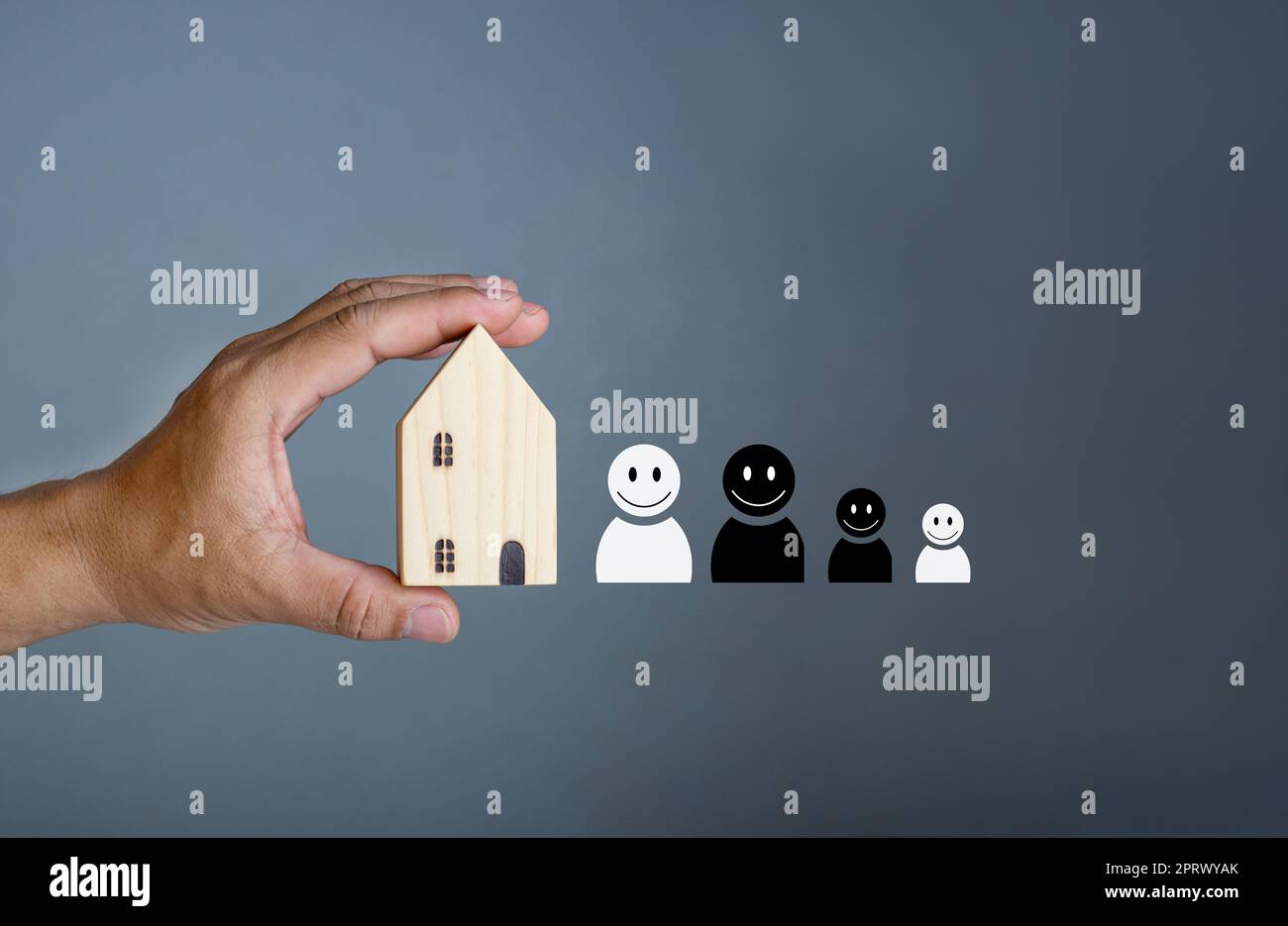 Concept de maison heureuse. Main tenant une maison modèle souriante. Indique le bonheur et l'amour dans la maison. Banque D'Images