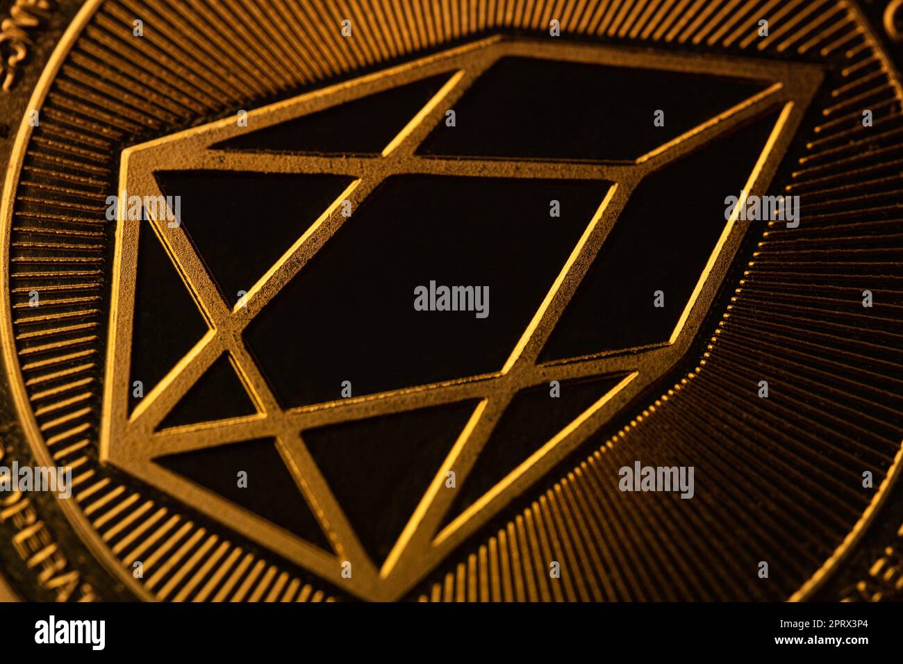 vue de dessus macro extrême gros plan de la pièce de monnaie dorée crypto eos avec logo géométrique Banque D'Images