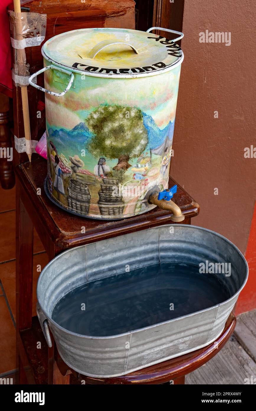 Un poste de lavage des mains avec une scène pastorale peinte dans un petit restaurant à Tlacolula de Matamoros, Oaxaca, Mexique. Banque D'Images