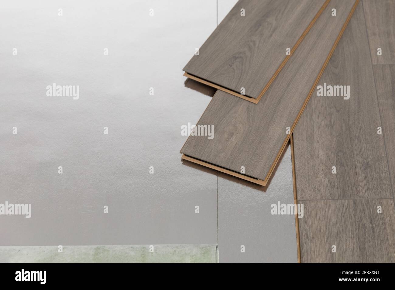 Installation de plancher flottant, sous-couche avec feuilles de stratifié. Concept d'amélioration de la maison. Banque D'Images
